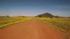 (c) Copyright - Raphael Kessler 2011 - Namibia - Road to nowhere - Red dust road and yellow flowers